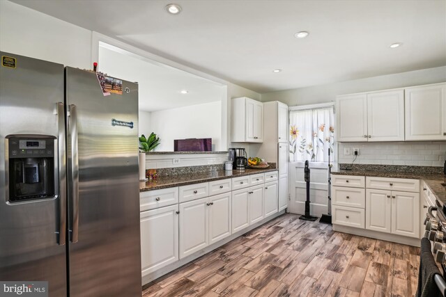 kitchen featuring white cabinetry, light wood-type flooring, dark stone counters, and stainless steel fridge with ice dispenser