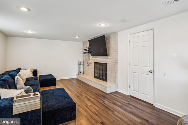 living room with a fireplace and dark hardwood / wood-style flooring