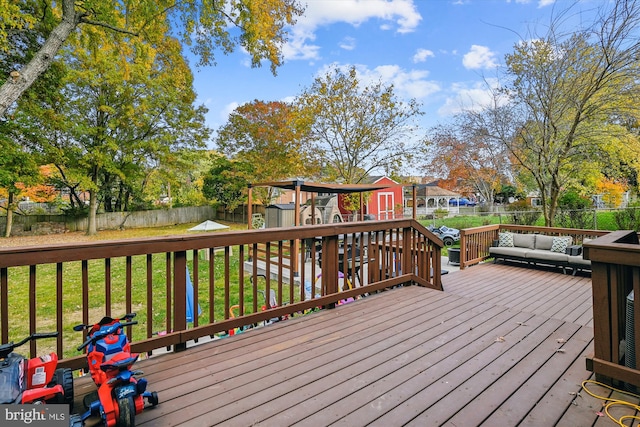 wooden deck with a playground and a yard