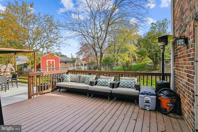 wooden deck featuring a shed and an outdoor hangout area