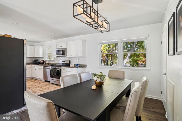 dining space featuring sink and light wood-type flooring