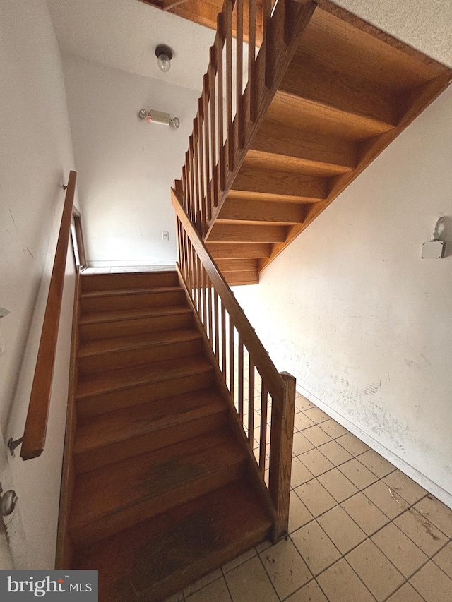 stairway featuring tile patterned flooring