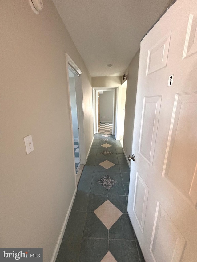 hall featuring dark tile patterned flooring