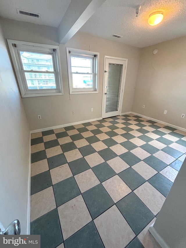 unfurnished room with a textured ceiling