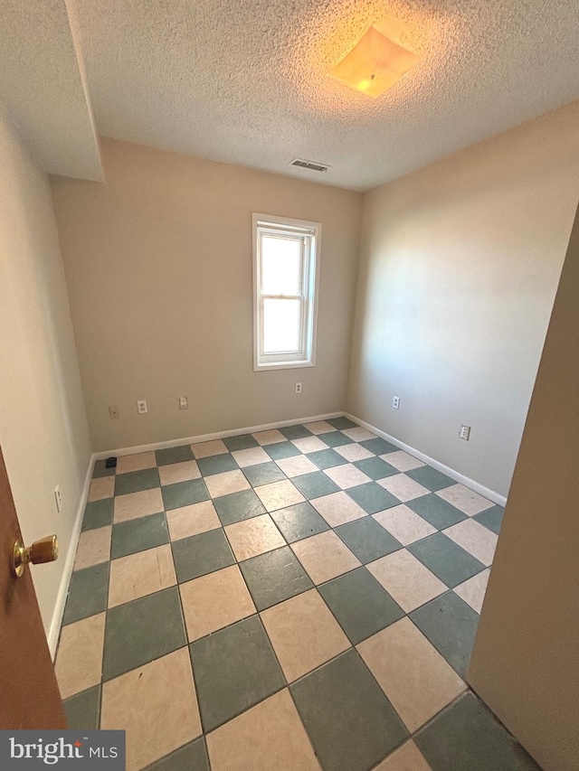 spare room with a textured ceiling