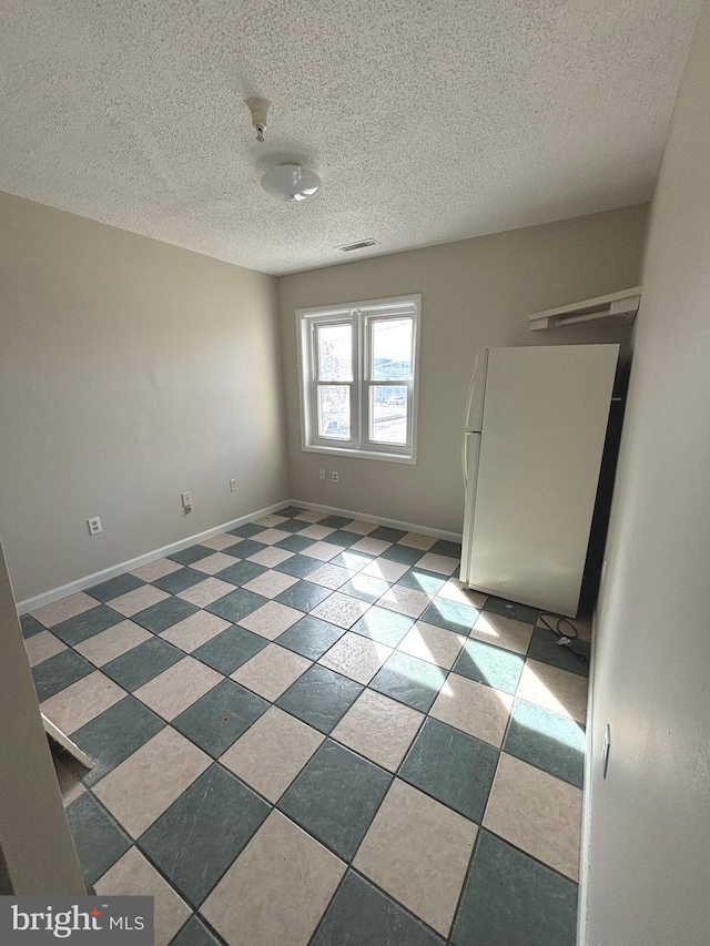 spare room with a textured ceiling