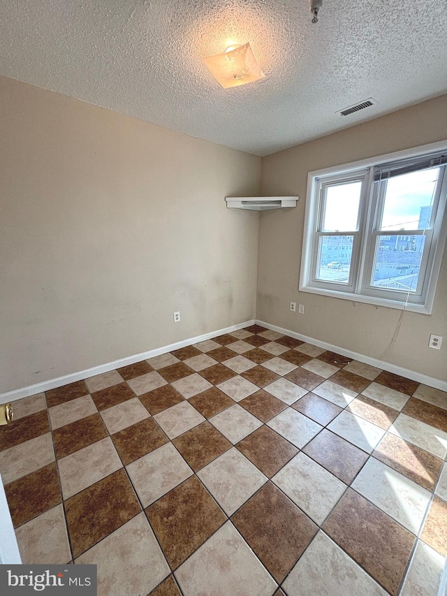 spare room with a textured ceiling