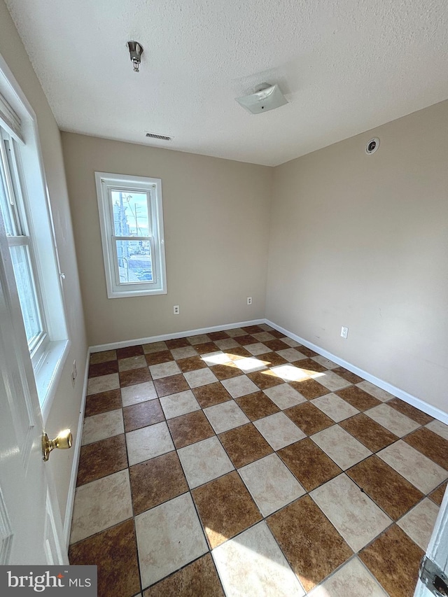 unfurnished room featuring a textured ceiling