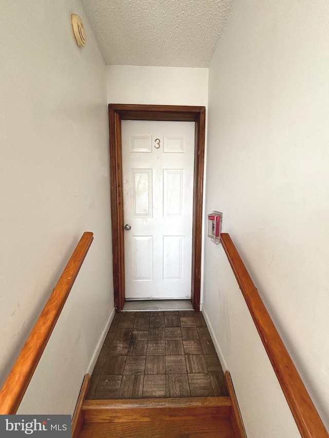 entryway featuring a textured ceiling and dark hardwood / wood-style flooring