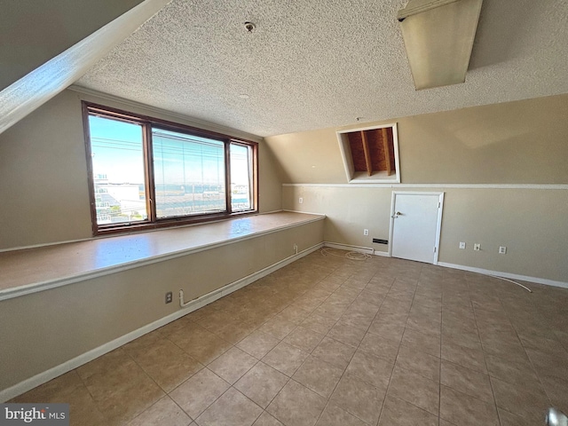 bonus room featuring a textured ceiling, tile patterned flooring, and vaulted ceiling