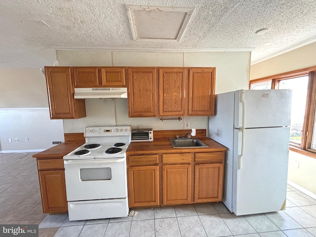 kitchen with a textured ceiling, sink, light tile patterned floors, and white appliances