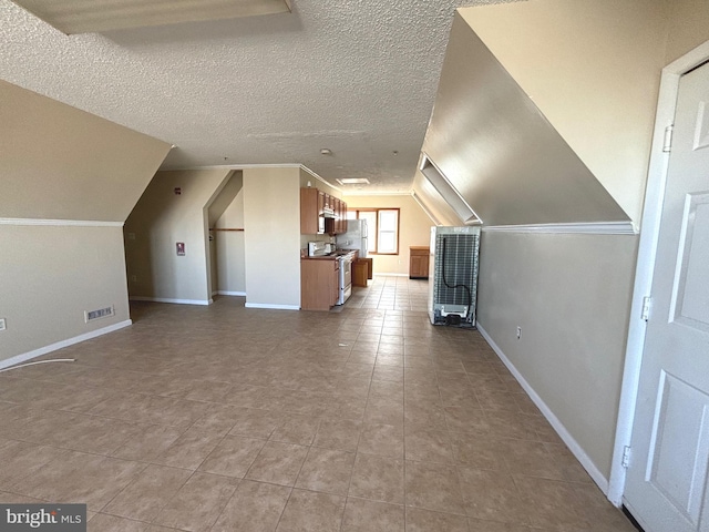 bonus room with vaulted ceiling and a textured ceiling