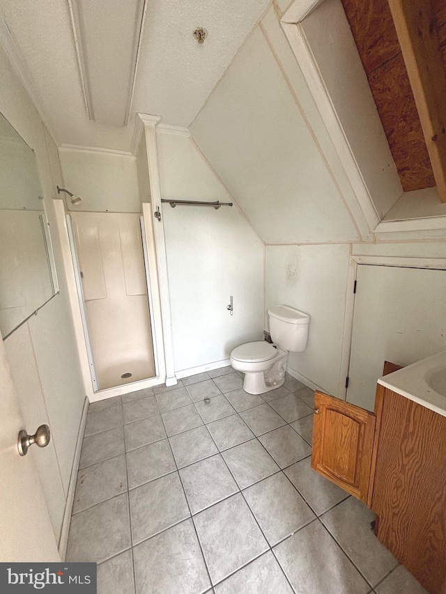 bathroom with tile patterned floors, toilet, vaulted ceiling, vanity, and walk in shower