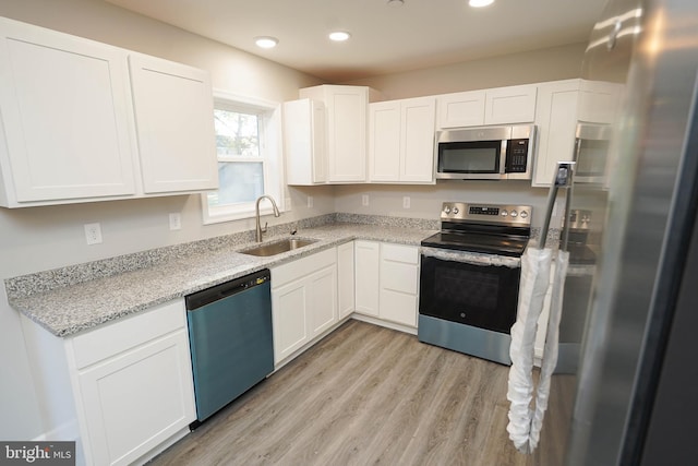 kitchen featuring sink, appliances with stainless steel finishes, and white cabinetry