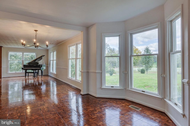 interior space featuring dark parquet floors and a notable chandelier