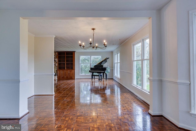 misc room featuring a notable chandelier, a healthy amount of sunlight, and crown molding