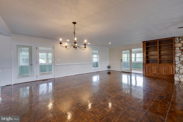 interior space with ornamental molding, a textured ceiling, and an inviting chandelier