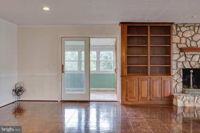 unfurnished living room featuring tile patterned flooring, a stone fireplace, and crown molding