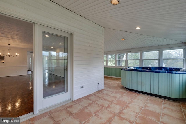 unfurnished sunroom with vaulted ceiling, a hot tub, a notable chandelier, and wood ceiling