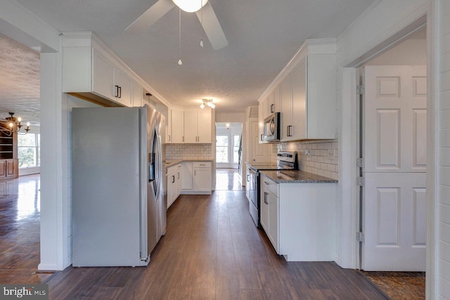 kitchen featuring a healthy amount of sunlight, dark hardwood / wood-style flooring, white cabinets, and stainless steel appliances