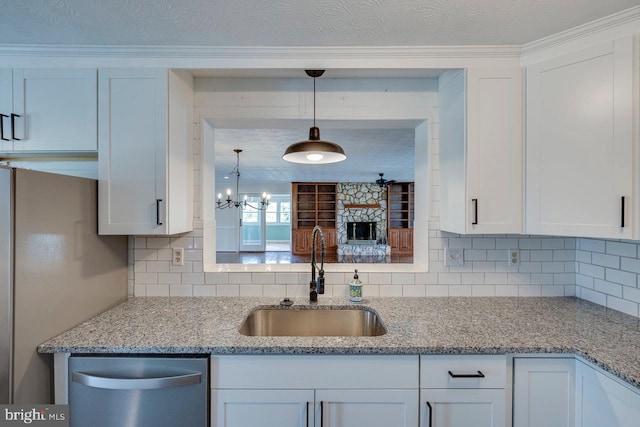 kitchen with white cabinets, decorative light fixtures, stainless steel appliances, and sink