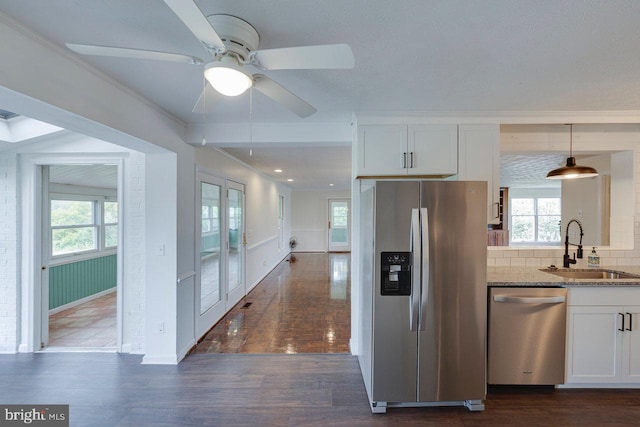 kitchen with pendant lighting, sink, dark hardwood / wood-style floors, white cabinetry, and stainless steel appliances