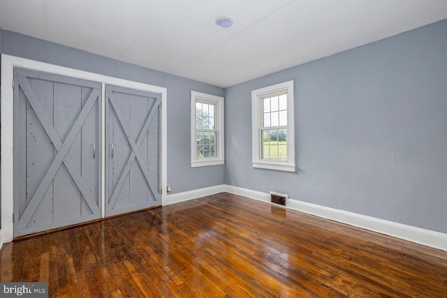 unfurnished room with dark hardwood / wood-style flooring