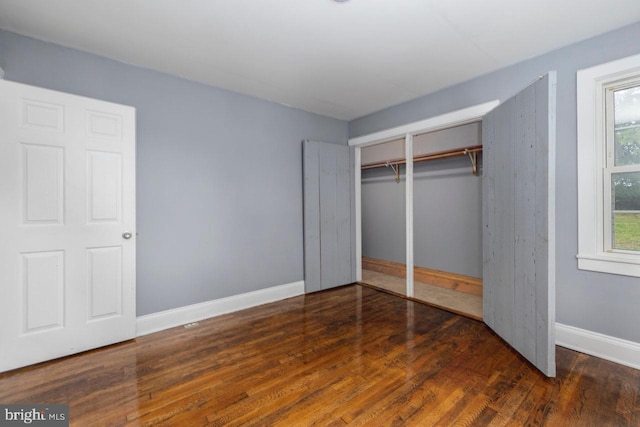 unfurnished bedroom featuring dark hardwood / wood-style flooring and a closet