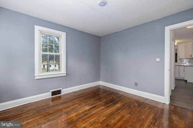 spare room with dark hardwood / wood-style floors