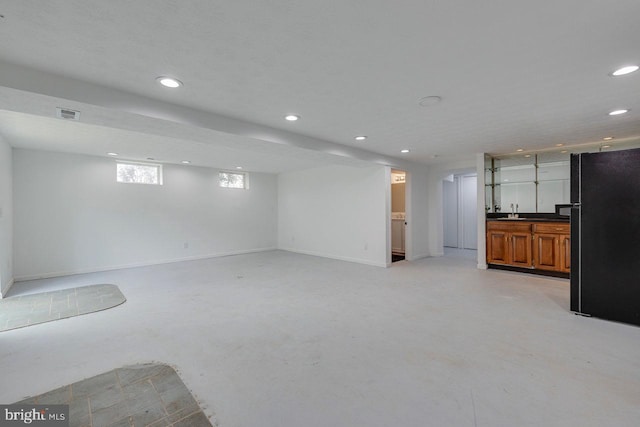 unfurnished living room featuring sink and a textured ceiling