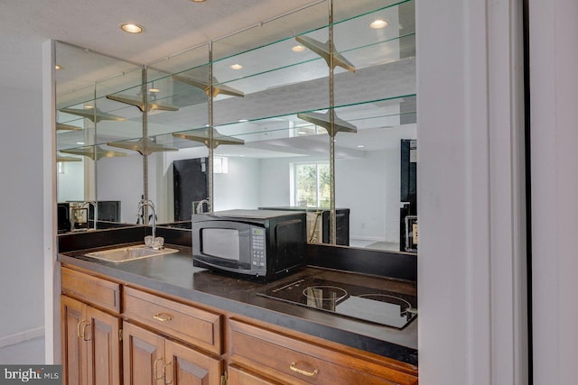 kitchen with sink, black appliances, and a textured ceiling