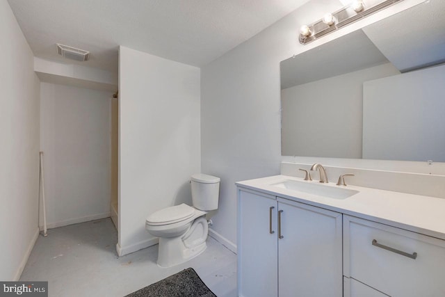 bathroom with vanity, a textured ceiling, concrete floors, and toilet