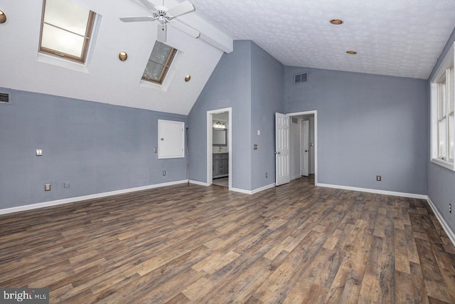 unfurnished living room with ceiling fan, dark hardwood / wood-style flooring, and a skylight