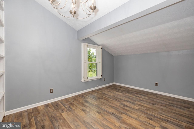 additional living space featuring a notable chandelier, vaulted ceiling with beams, and dark hardwood / wood-style floors