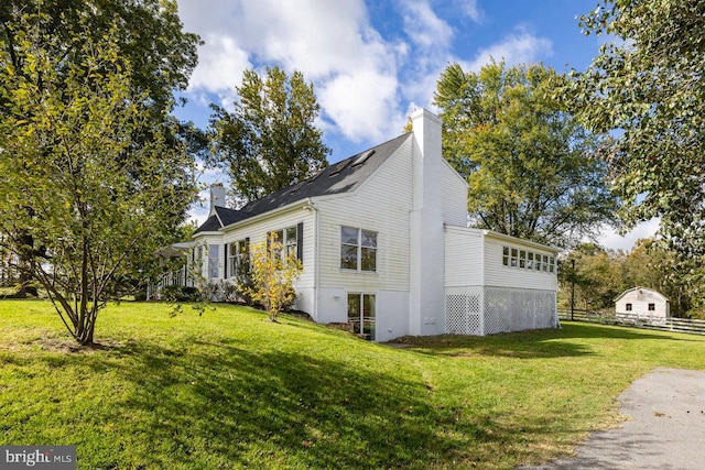 view of side of home with a yard