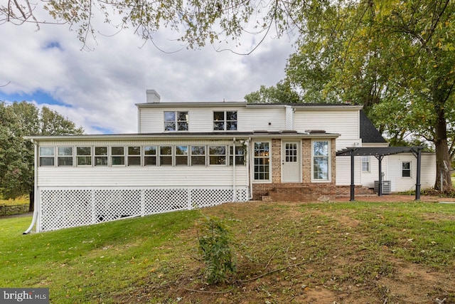 rear view of house featuring a lawn and a pergola