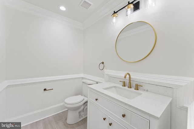 bathroom with ornamental molding, vanity, and toilet