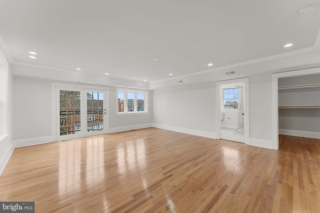 unfurnished living room featuring ornamental molding and light wood-type flooring