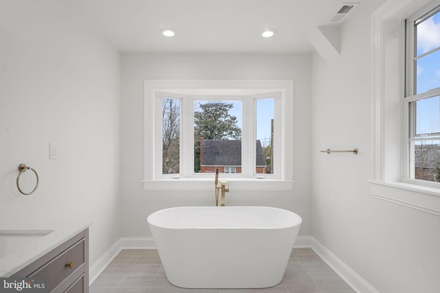 bathroom featuring a tub to relax in and vanity