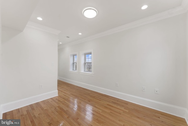 empty room with ornamental molding and light wood-type flooring