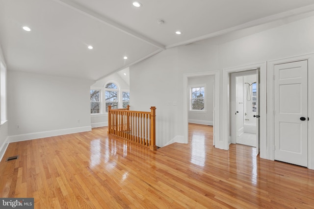 interior space featuring lofted ceiling with beams and light hardwood / wood-style flooring