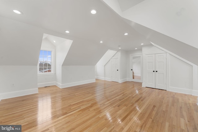 additional living space with lofted ceiling and light hardwood / wood-style floors