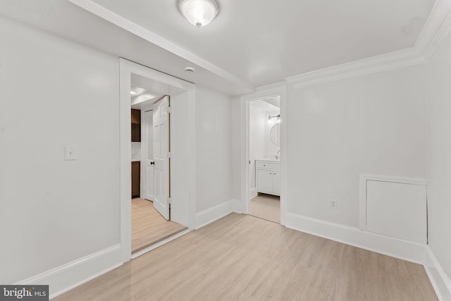 interior space featuring ornamental molding, light hardwood / wood-style floors, and ensuite bath