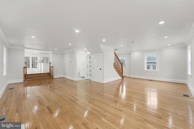 unfurnished living room with crown molding and light hardwood / wood-style floors