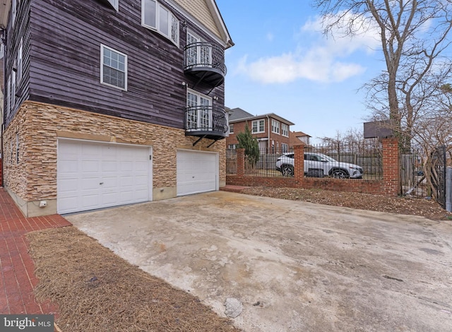 view of side of property featuring a garage and a balcony