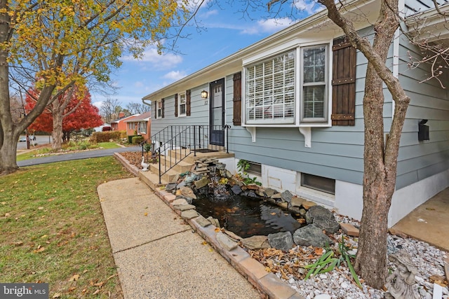 view of property exterior with a garden pond and a yard