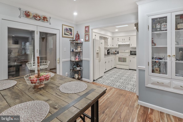 dining area with light hardwood / wood-style floors and ornamental molding