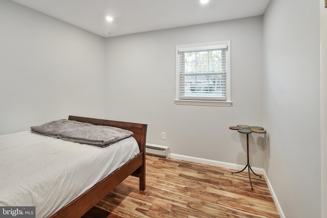 bedroom featuring light wood-type flooring and baseboard heating