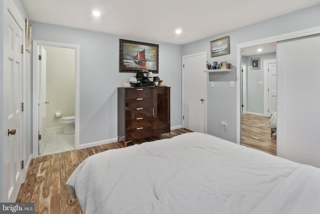 bedroom featuring hardwood / wood-style floors and ensuite bathroom