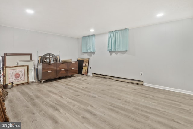 interior space with light hardwood / wood-style flooring and a baseboard heating unit